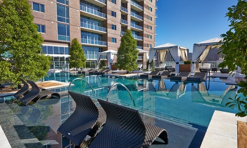 Resort-style pool with expansive tanning areas, private cabanas, and an unparalleled view of Dallas - Work and Play in Total Comfort